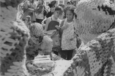 Performers wearing costumes crocheted by the artist Olek wordlessly interact with crowds at a mini "Bushwick Art Park" installed on the Bowery as part of the New Museum's Festival of Ideas.